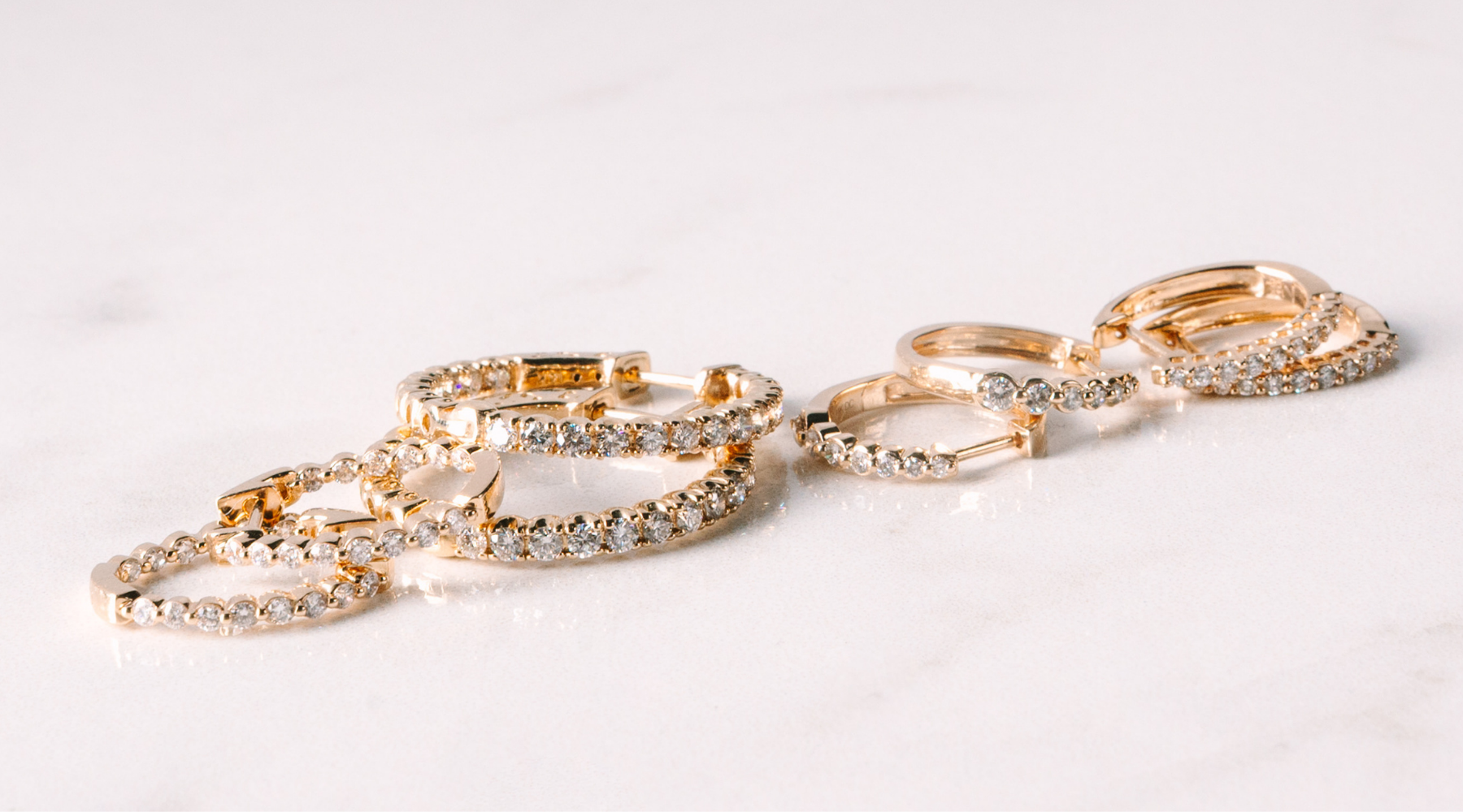14K gold diamond hoop earrings, elegant fine jewelry for everyday wear on marble surface