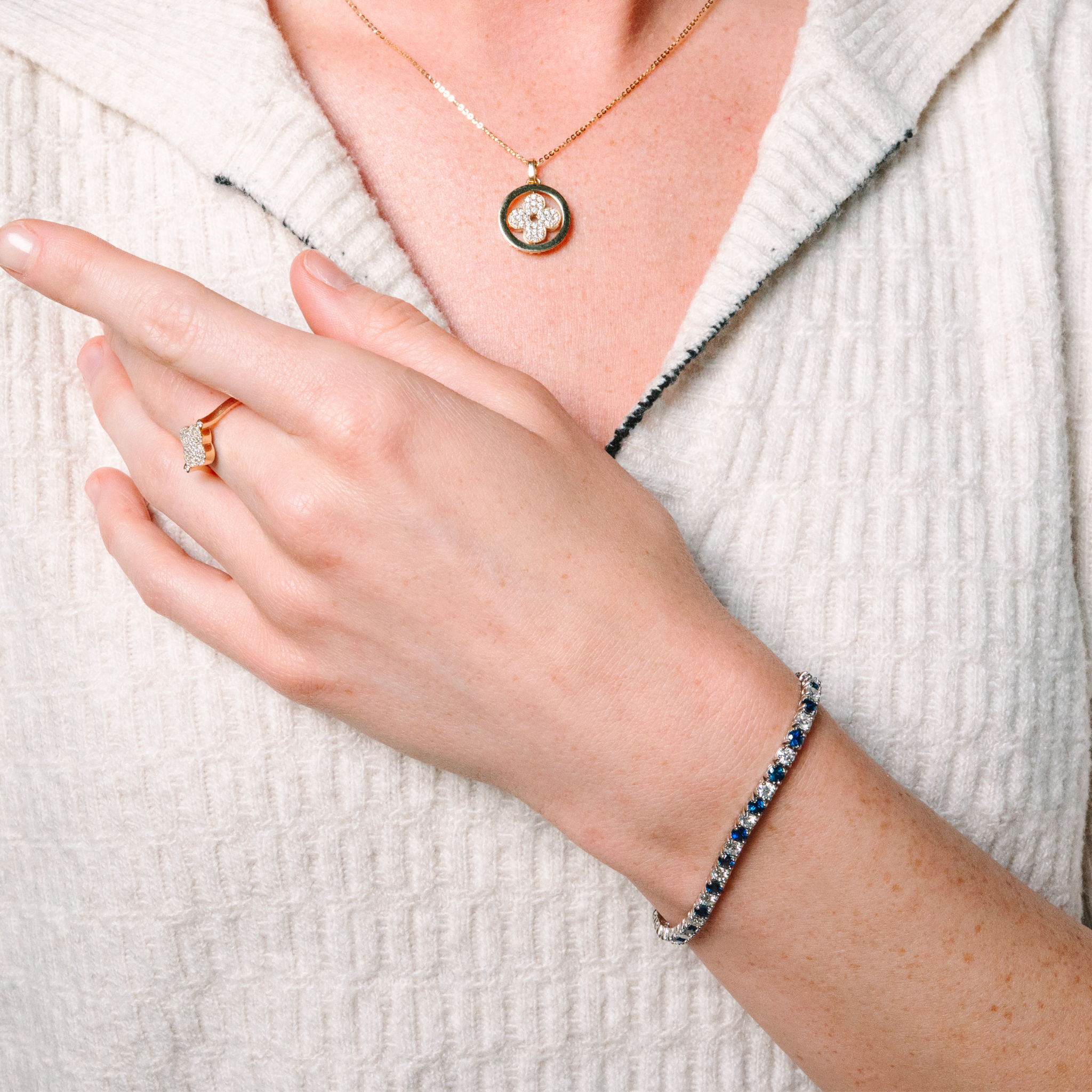 Woman wearing 14K gold diamond necklace, ring, and sapphire bracelet — timeless fine jewelry for everyday wear