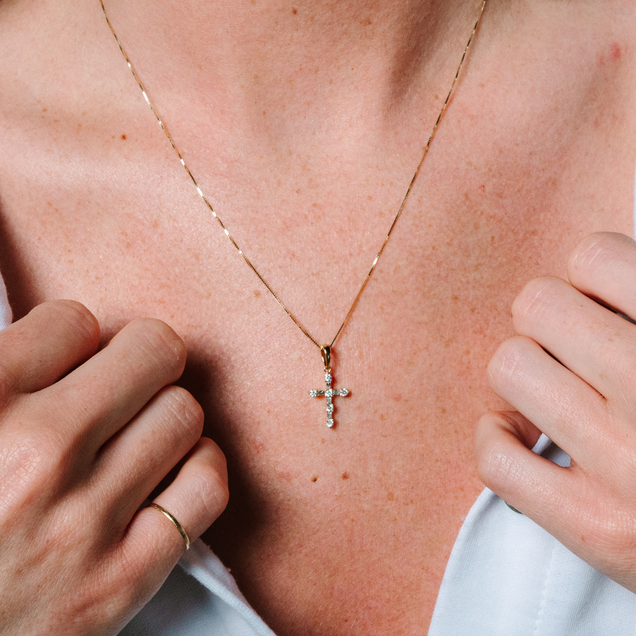 14K gold diamond cross necklace on woman's chest, delicate chain with sparkling stones, everyday fine jewelry
