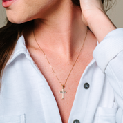 Woman wearing 14K gold diamond cross necklace, elegant everyday fine jewelry