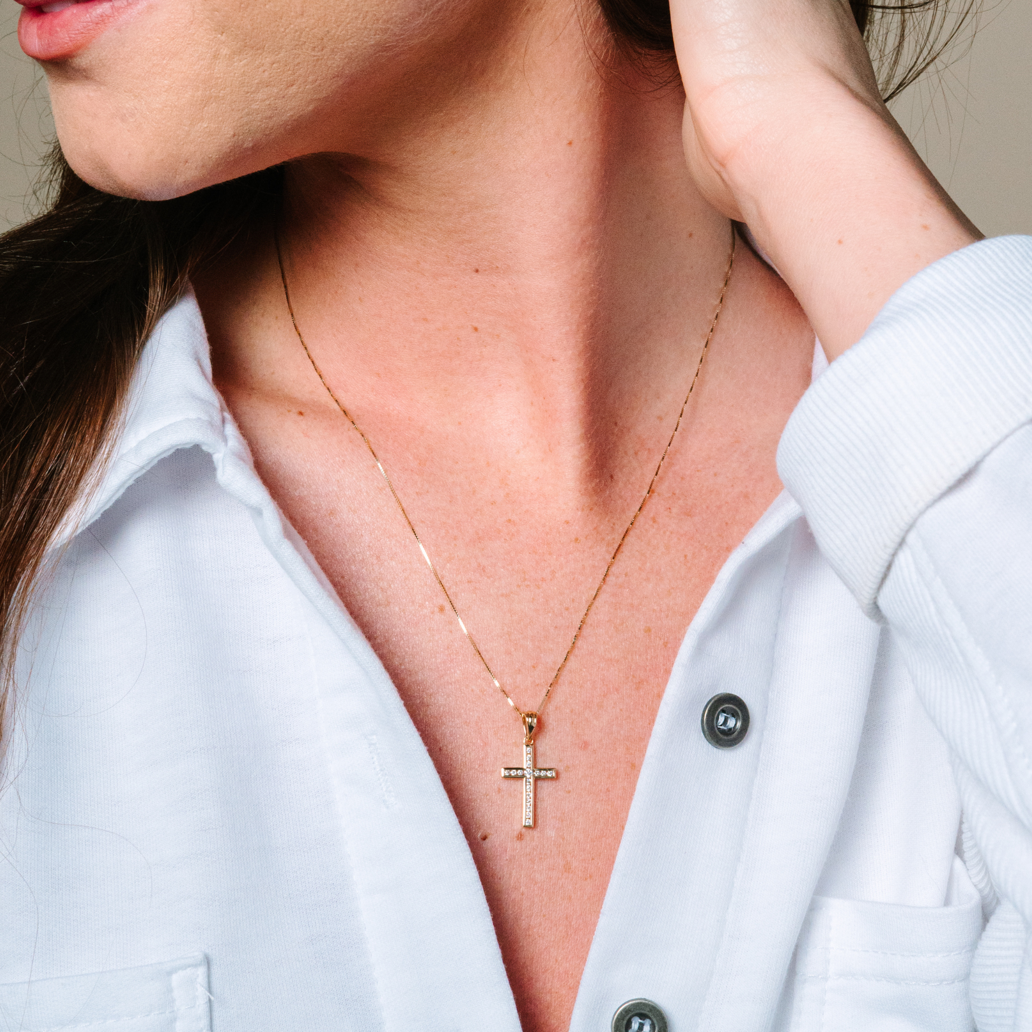 Woman wearing 14K gold diamond cross necklace, elegant everyday fine jewelry