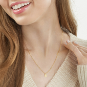 Delicate 14K gold heart necklace on woman, everyday fine jewelry with chain pendant