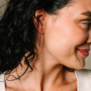 Elegant 14K gold drop earrings with diamonds, worn by woman with curly hair, timeless fine jewelry