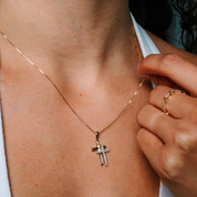 14K gold cross necklace with diamond accents, worn with delicate chain and matching ring