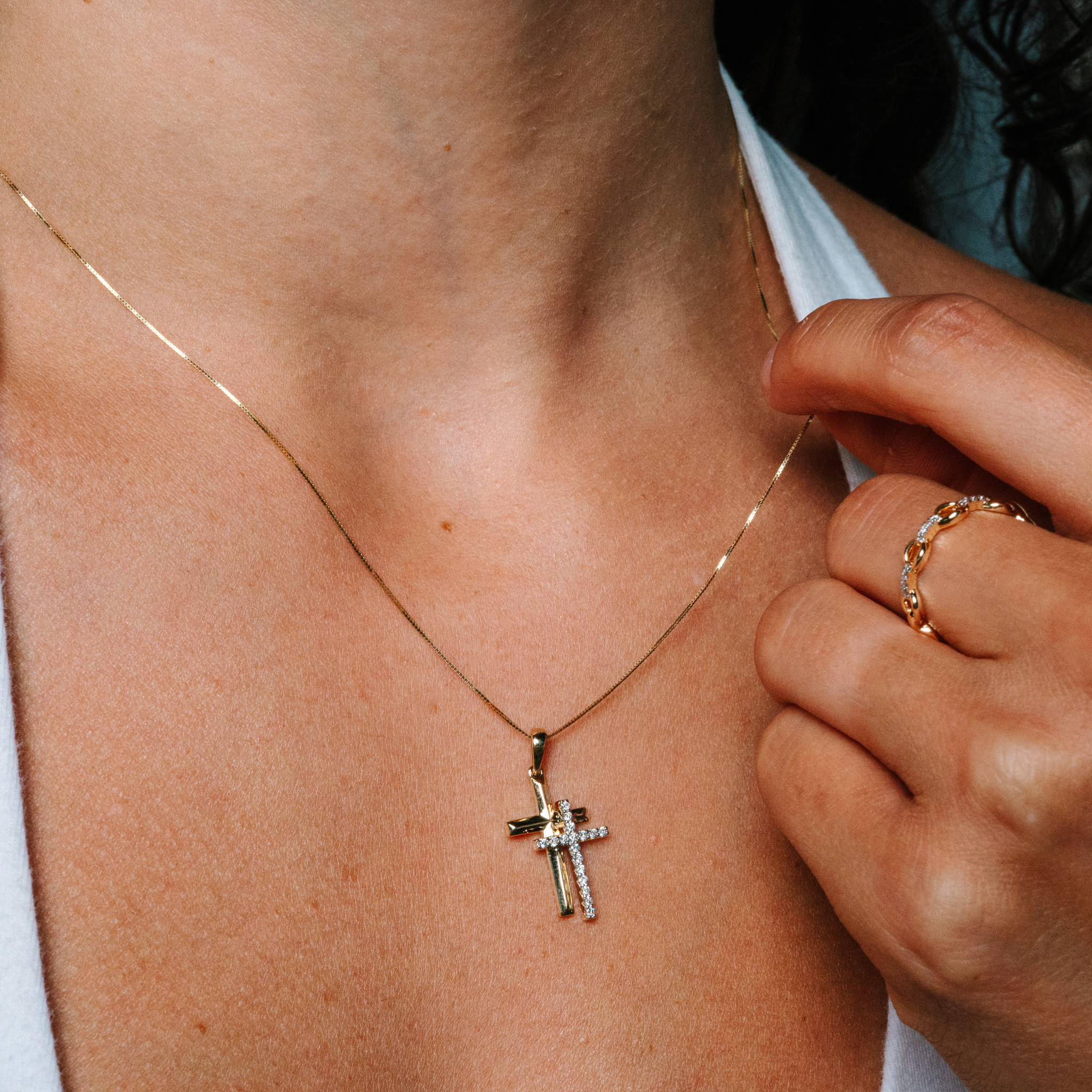 14K gold cross necklace with diamond accents, worn with delicate chain and matching ring