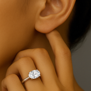 Oval diamond solitaire ring in 14K gold, elegantly worn on finger near ear
