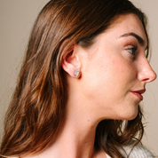 Woman wearing 14K gold emerald cut diamond stud earrings, timeless fine jewelry for everyday wear