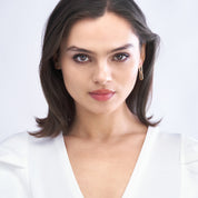 Woman wearing minimalist gold hoop earrings, 14K gold fine jewelry for everyday wear