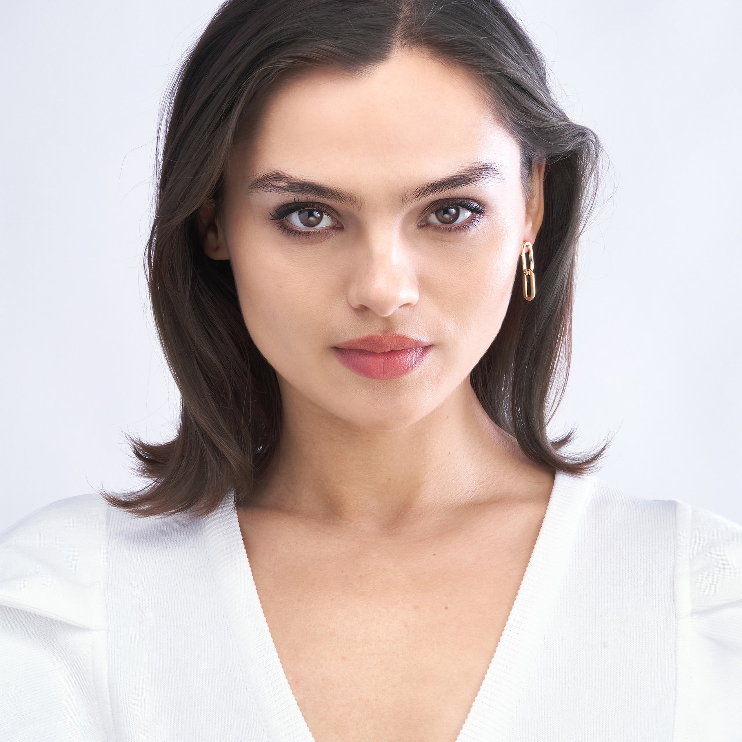 Woman wearing minimalist gold hoop earrings, 14K gold fine jewelry for everyday wear