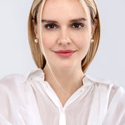 Woman wearing 14K gold stud earrings with textured finish, styled with white blouse for everyday elegance.