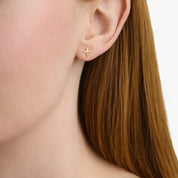 14K gold cross stud earring on woman's ear, minimalist fine jewelry for everyday wear