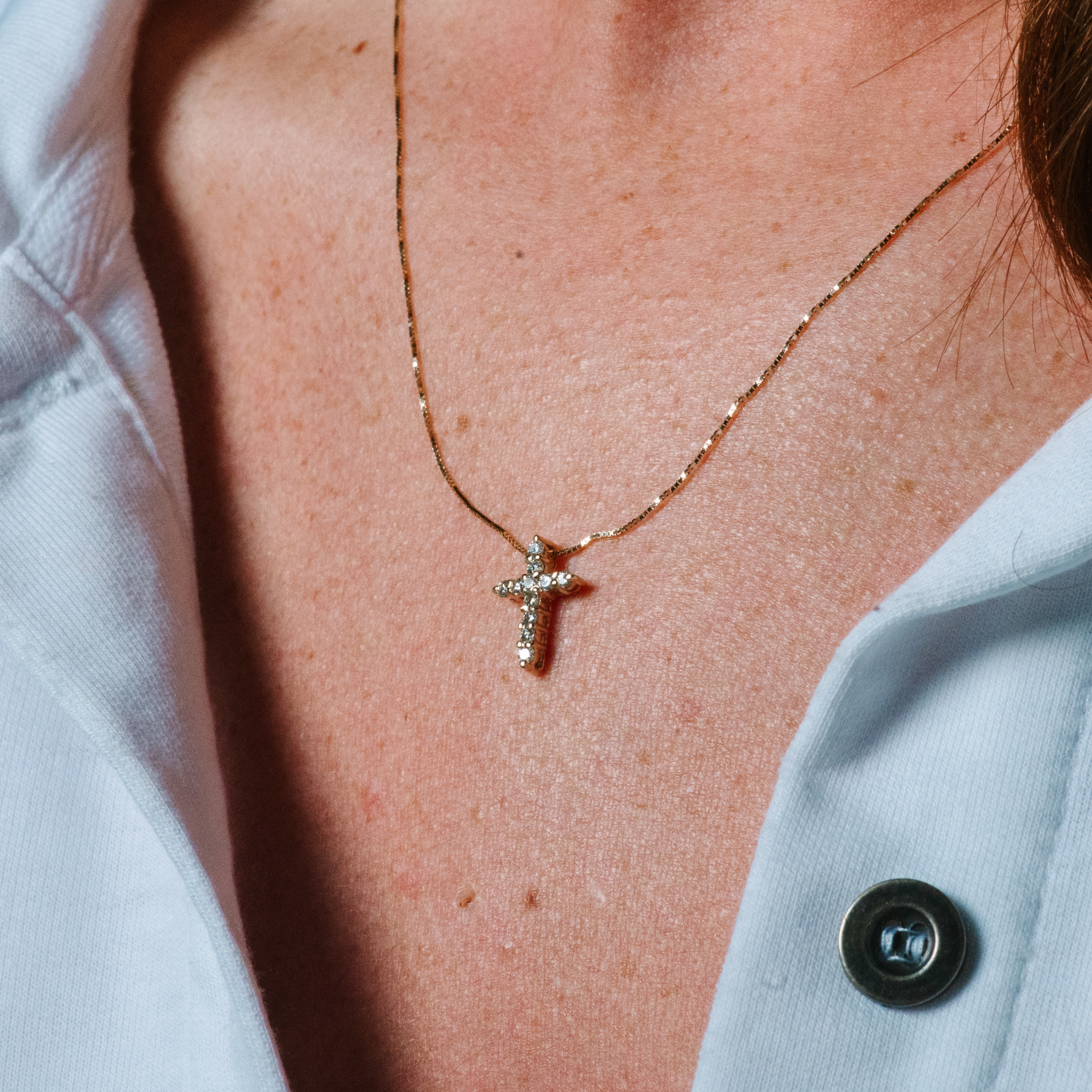 14K gold cross necklace with diamonds, worn on chest, everyday fine jewelry