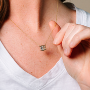 14K gold necklace with emerald cut diamond pendant, worn close-up on model