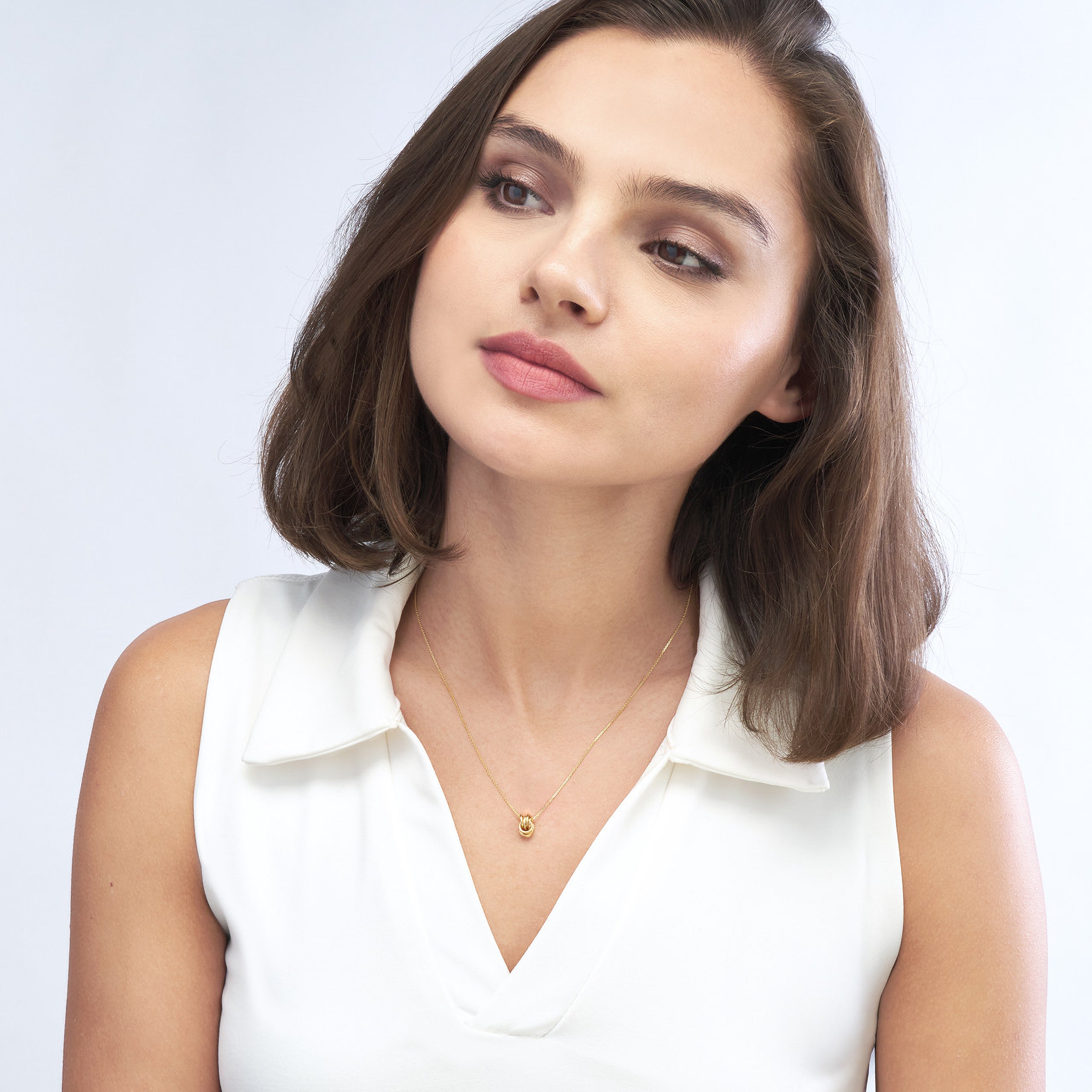 Woman wearing 14K gold knot necklace, timeless fine jewelry for everyday wear