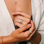 Elegant 14K gold diamond engagement ring with emerald cut center stone, paired with matching band and necklace
