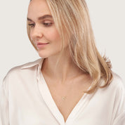 Woman wearing delicate 14K gold heart necklace, timeless fine jewelry for everyday wear