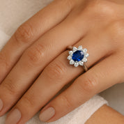 Elegant sapphire and diamond halo ring in 14K gold, worn on hand, timeless fine jewelry piece