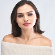 Woman wearing 14K gold teardrop necklace with diamond, fine jewelry for everyday wear