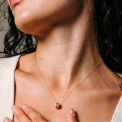Woman wearing delicate 14K gold necklace with diamond-accented pendant, perfect for everyday wear