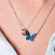 Layered 14K gold necklaces with blue butterfly pendant and colorful gemstone charm, fine jewelry for everyday wear