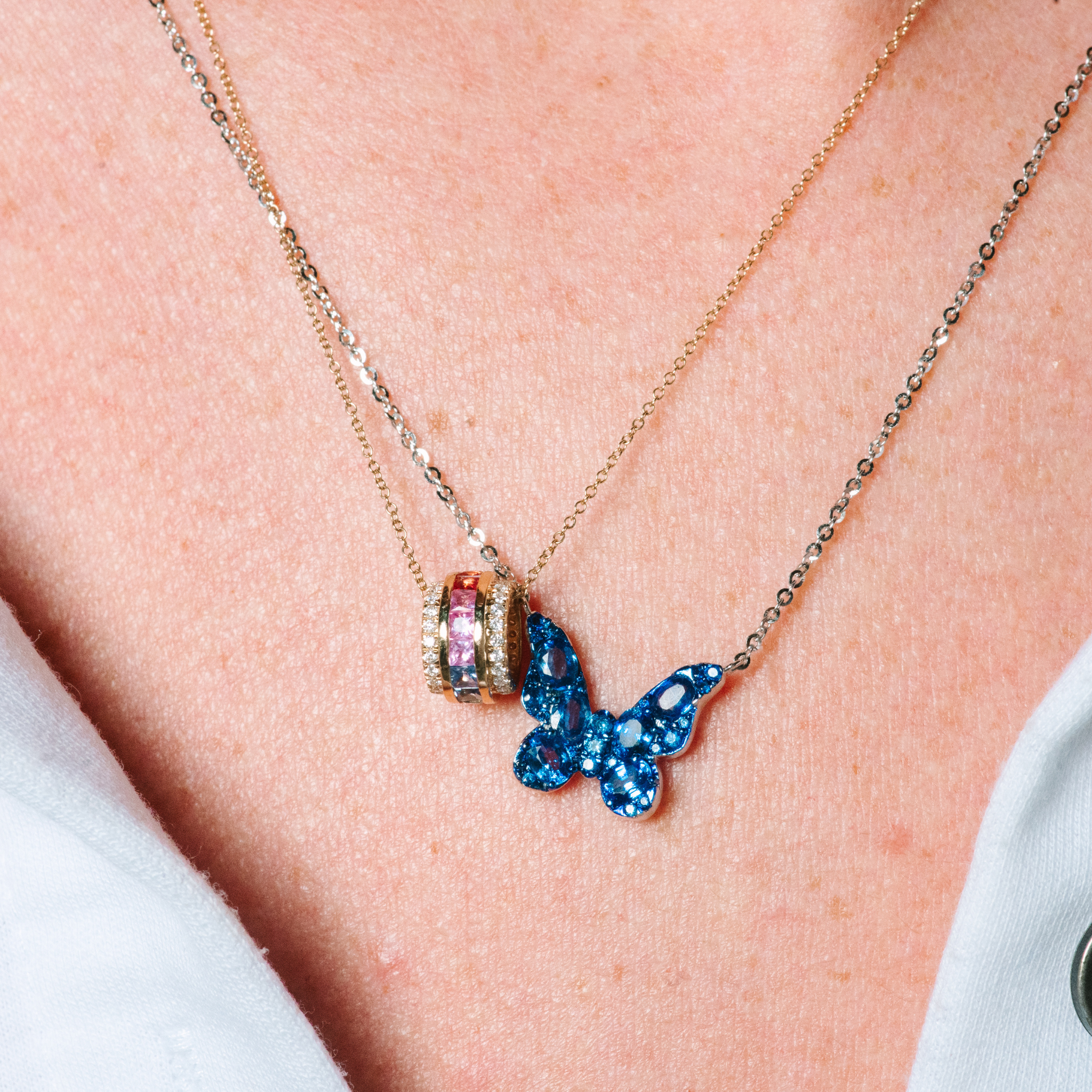 Layered 14K gold necklaces with blue butterfly pendant and colorful gemstone charm, fine jewelry for everyday wear