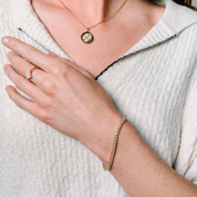 14K gold diamond necklace, bracelet, and ring set worn with a white textured top