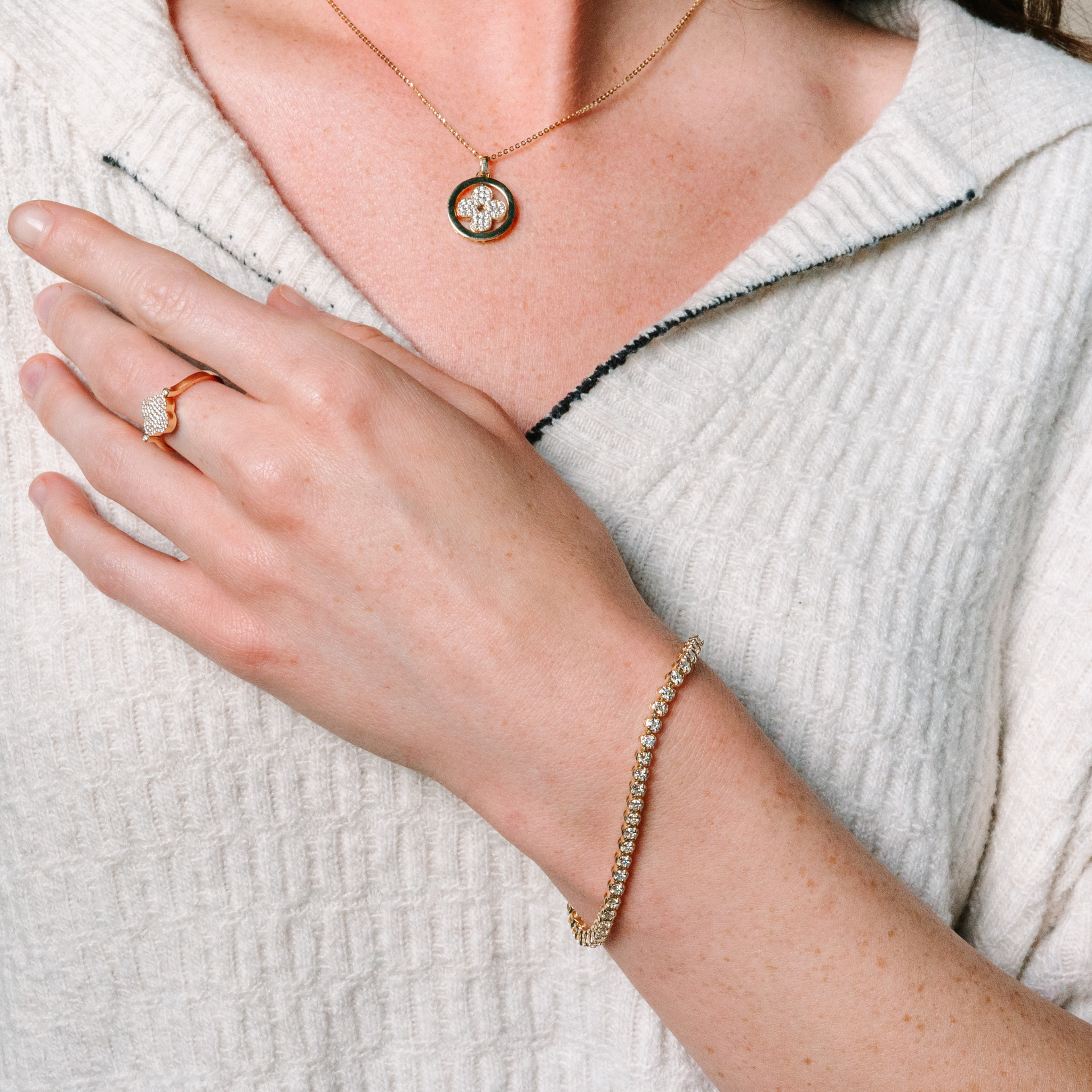 14K gold diamond necklace, bracelet, and ring set worn with a white textured top