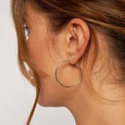 Gold hoop earring on woman's ear, 14K fine jewelry for everyday wear