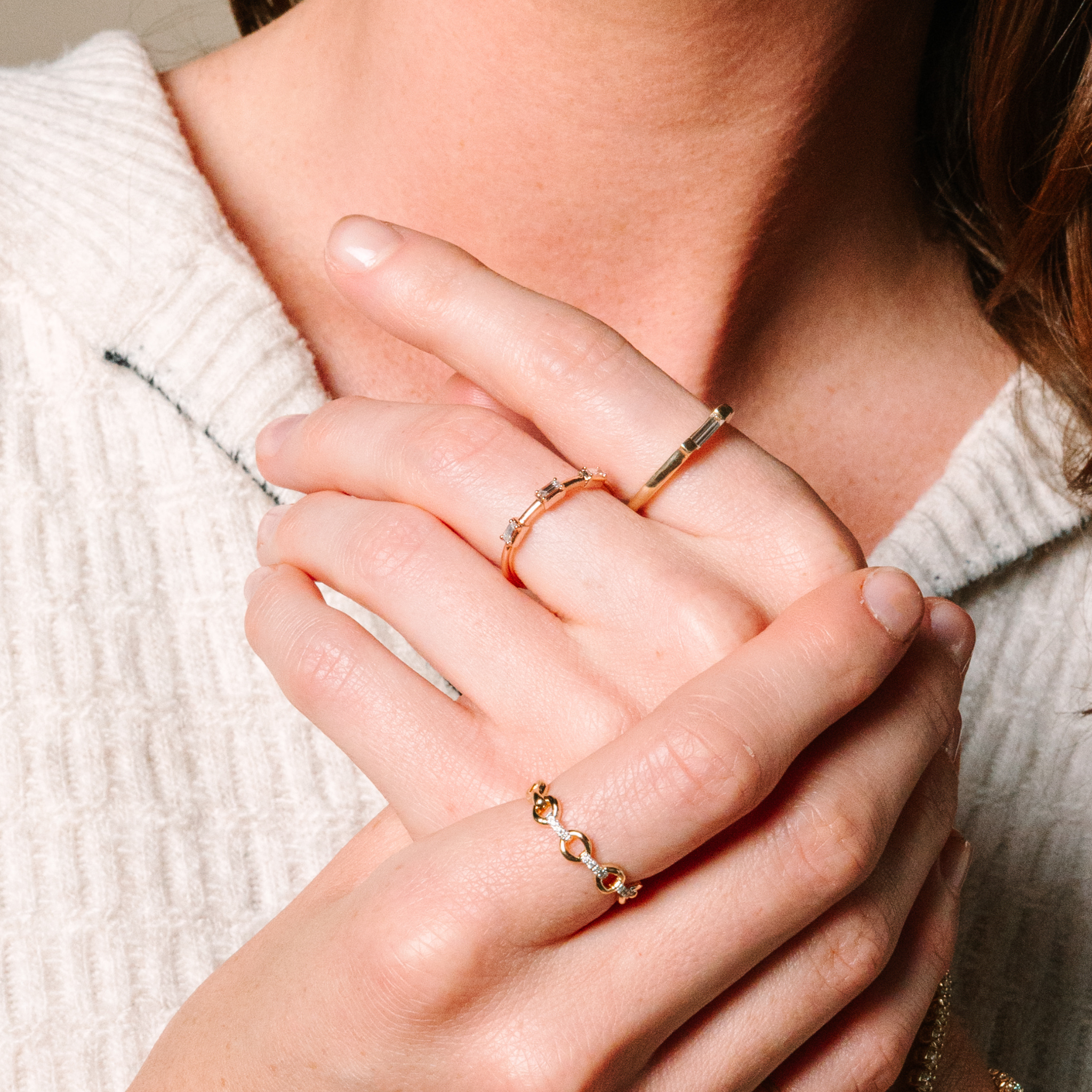 Elegant 14K gold rings with diamonds, layered on woman’s hand, perfect for everyday fine jewelry wear.