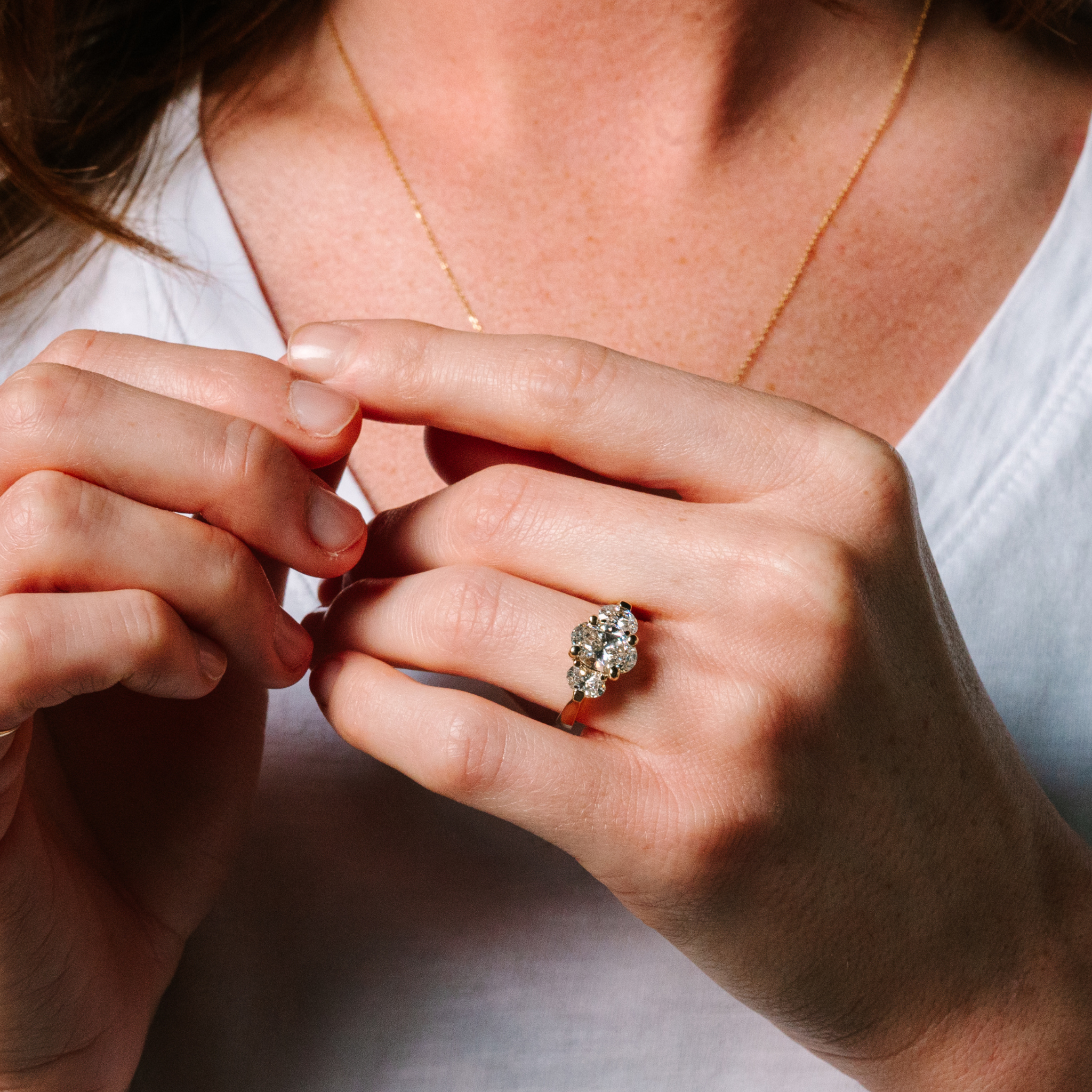 Woman wearing 14K gold diamond cluster ring with delicate necklace, timeless fine jewelry for everyday wear