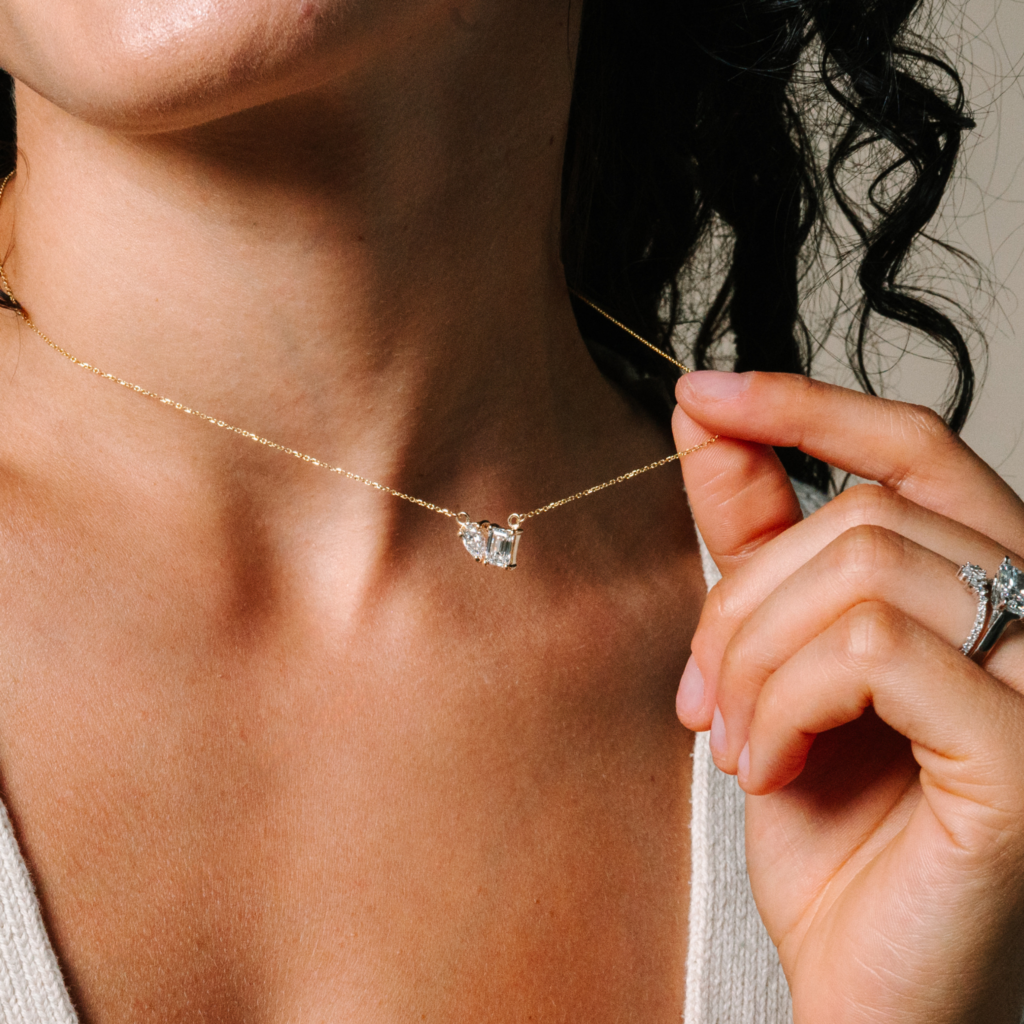 14K gold necklace with diamond pendant, worn by woman with diamond rings, timeless fine jewelry